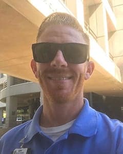 Smiling woman giving a piggyback ride to a laughing young girl.